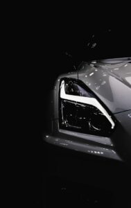 greyscale photo of sports car headlight